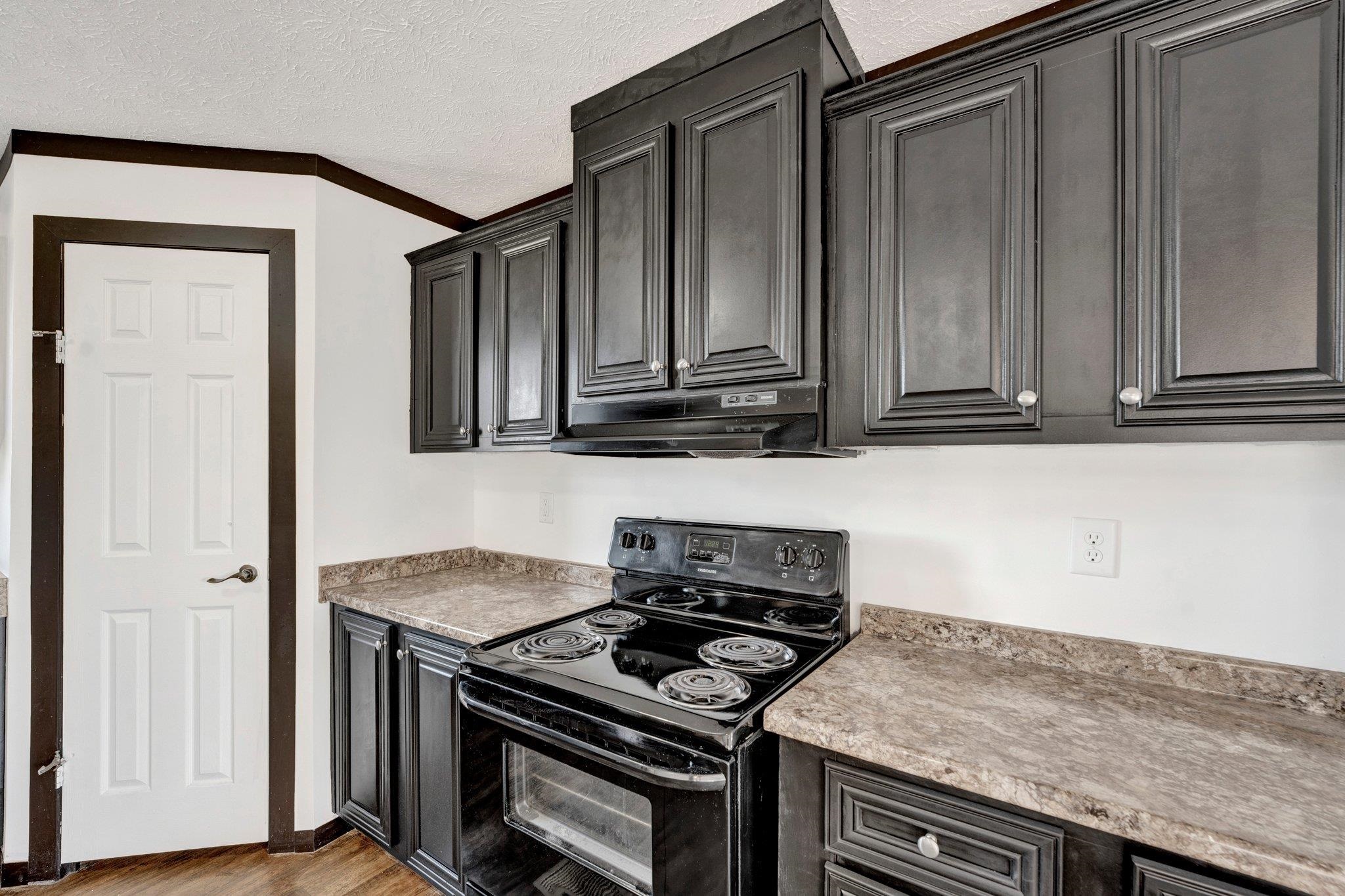 826 Nelson Road Brighton, TN 38011 - Photo 21 of 38 Kitchen with light hardwood / wood-style floors, crown molding, a textured ceiling, and black electric range