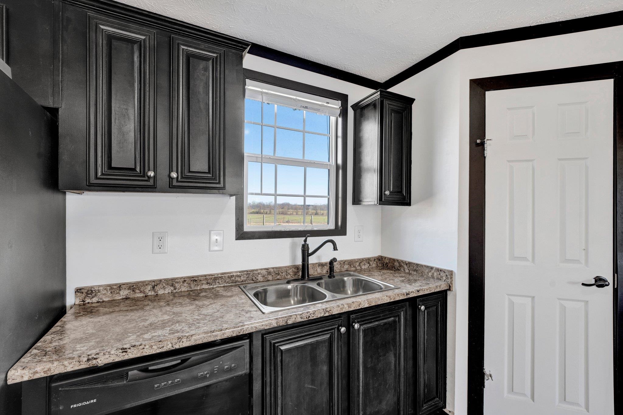 826 Nelson Road Brighton, TN 38011 - Photo 23 of 38 Kitchen featuring sink, a textured ceiling, and black dishwasher