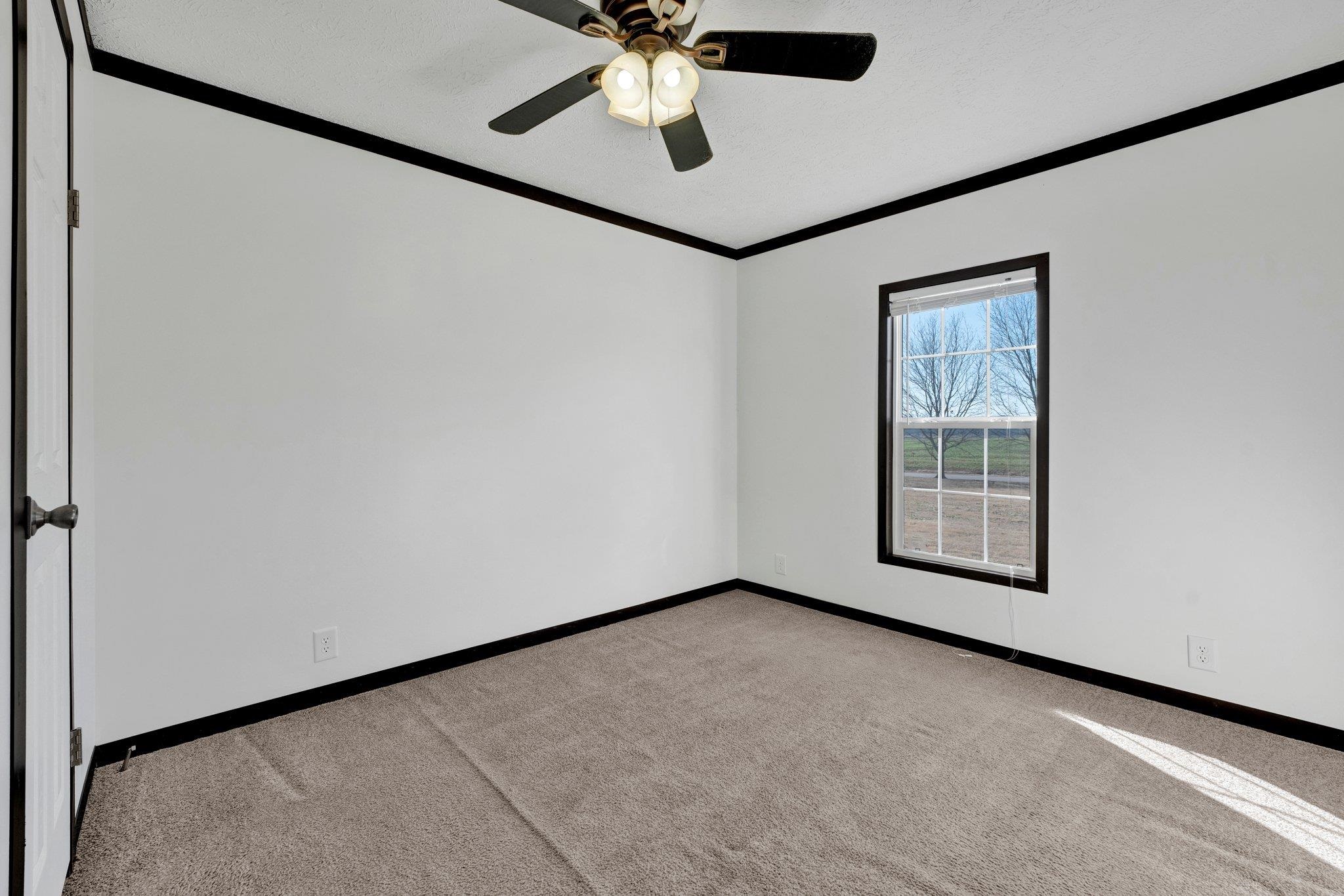 826 Nelson Road Brighton, TN 38011 - Photo 24 of 38 Empty room featuring ceiling fan, light colored carpet, and ornamental molding