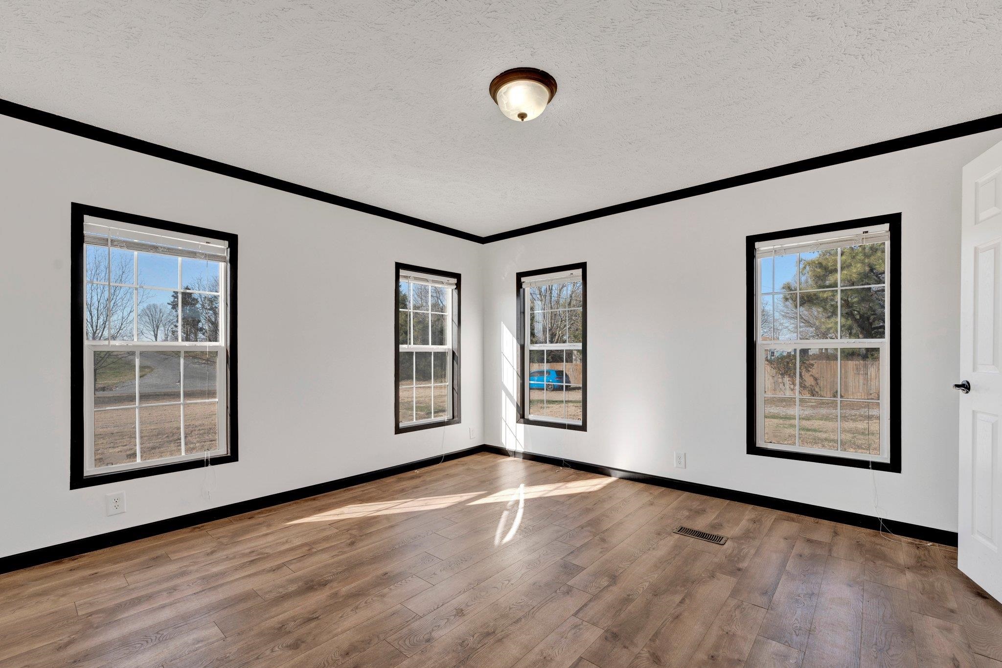 826 Nelson Road Brighton, TN 38011 - Photo 28 of 38 Empty room featuring hardwood / wood-style floors, a textured ceiling, and crown molding