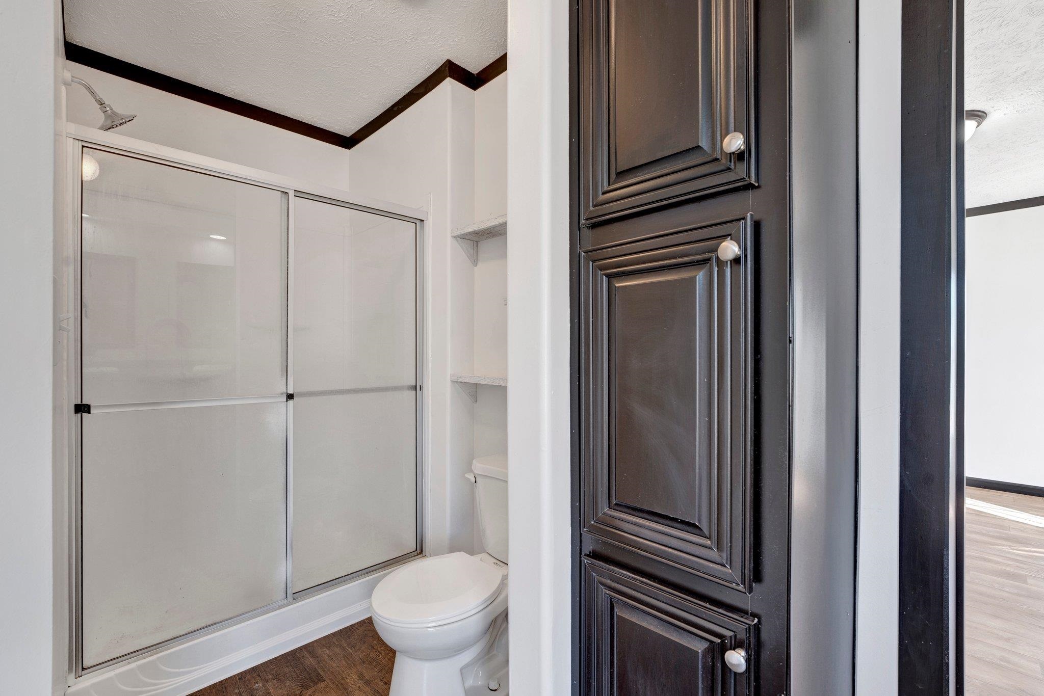 826 Nelson Road Brighton, TN 38011 - Photo 31 of 38 Bathroom with wood-type flooring, a textured ceiling, toilet, and walk in shower