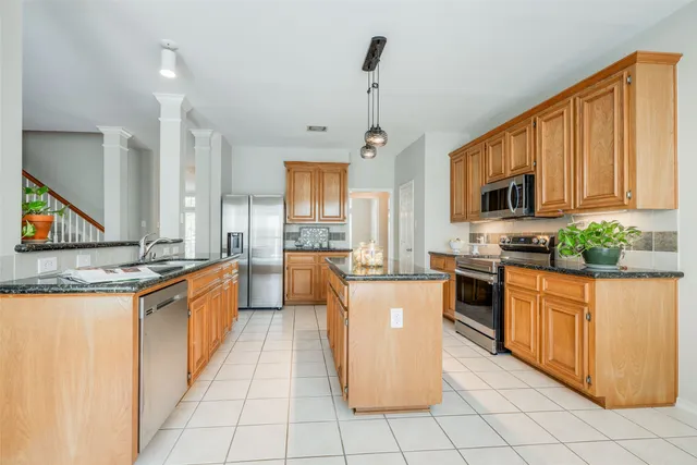 a large kitchen with stainless steel appliances granite countertop a stove a sink dishwasher a microwave oven and a refrigerator