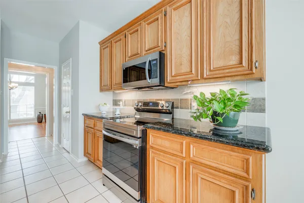a kitchen with stainless steel appliances granite countertop white cabinets a stove top oven and granite counter top