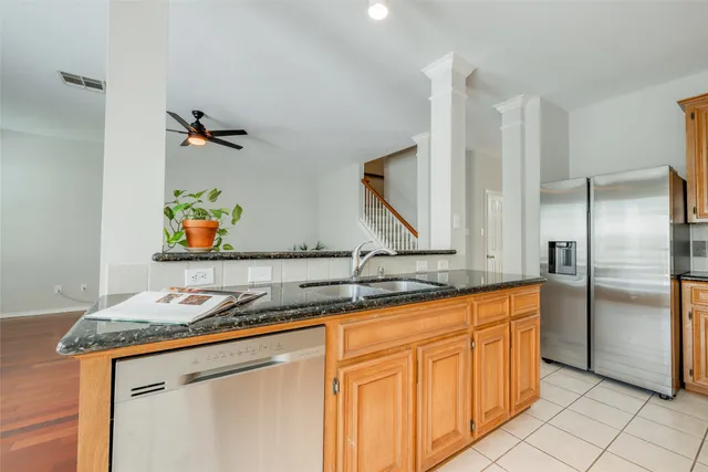 a kitchen with stainless steel appliances granite countertop a sink and a refrigerator