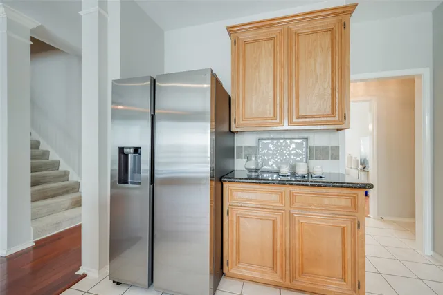 a kitchen with granite countertop a refrigerator and cabinets