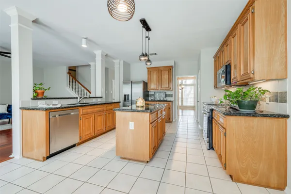 a kitchen with stainless steel appliances granite countertop a stove a sink and a refrigerator