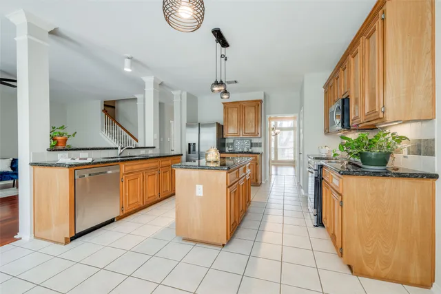 a kitchen with stainless steel appliances granite countertop a stove a sink and a refrigerator