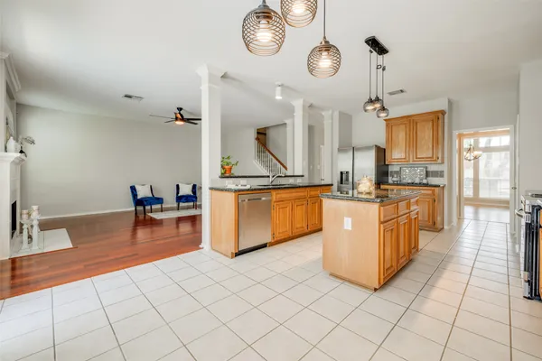 a large kitchen with stainless steel appliances granite countertop a sink and a refrigerator