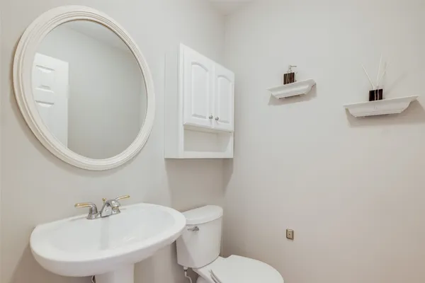 a bathroom with a toilet a sink and mirror