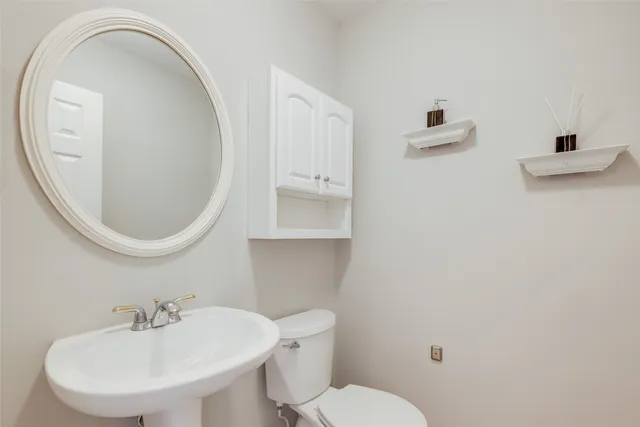 a bathroom with a toilet a sink and mirror