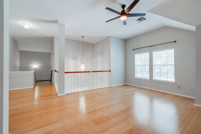 a view of a livingroom with wooden floor and a ceiling fan
