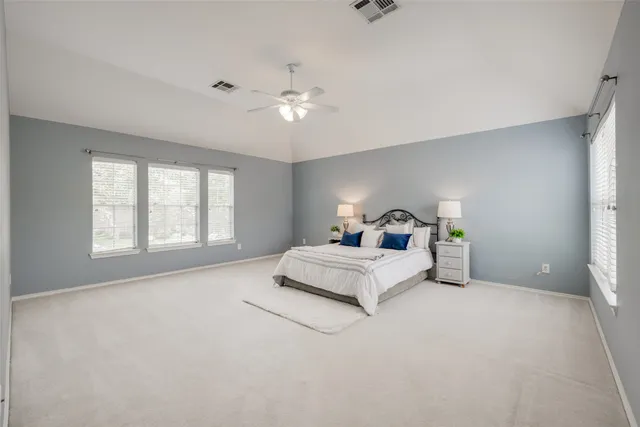 a spacious bedroom with a bed and window