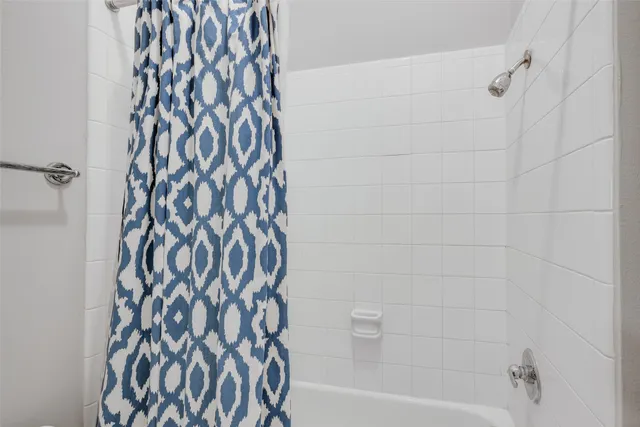 a bathroom with a bathtub and a shower curtain