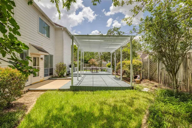 a view of a patio with table and chairs potted plants and large tree