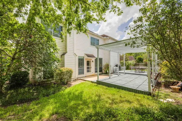 a view of a house with a patio and a yard