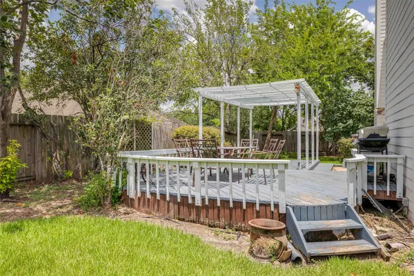 a view of a chair and table in backyard of the house