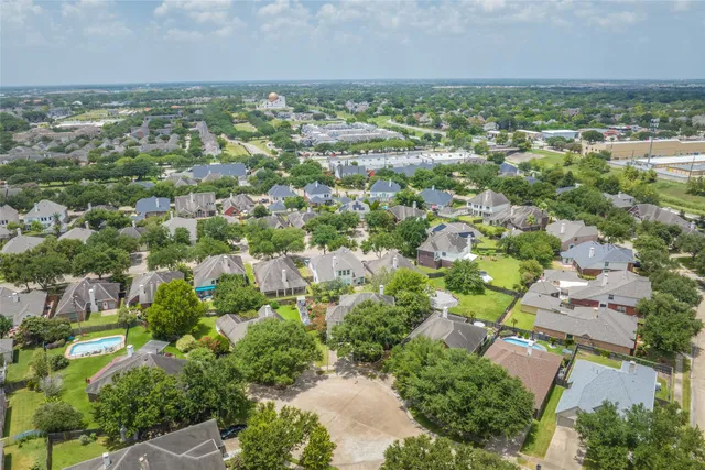 an aerial view of residential houses with outdoor space and trees