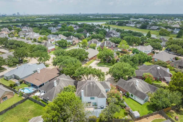 an aerial view of residential houses with outdoor space and trees