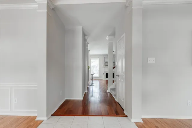 a view of a hallway with wooden floor and a living room