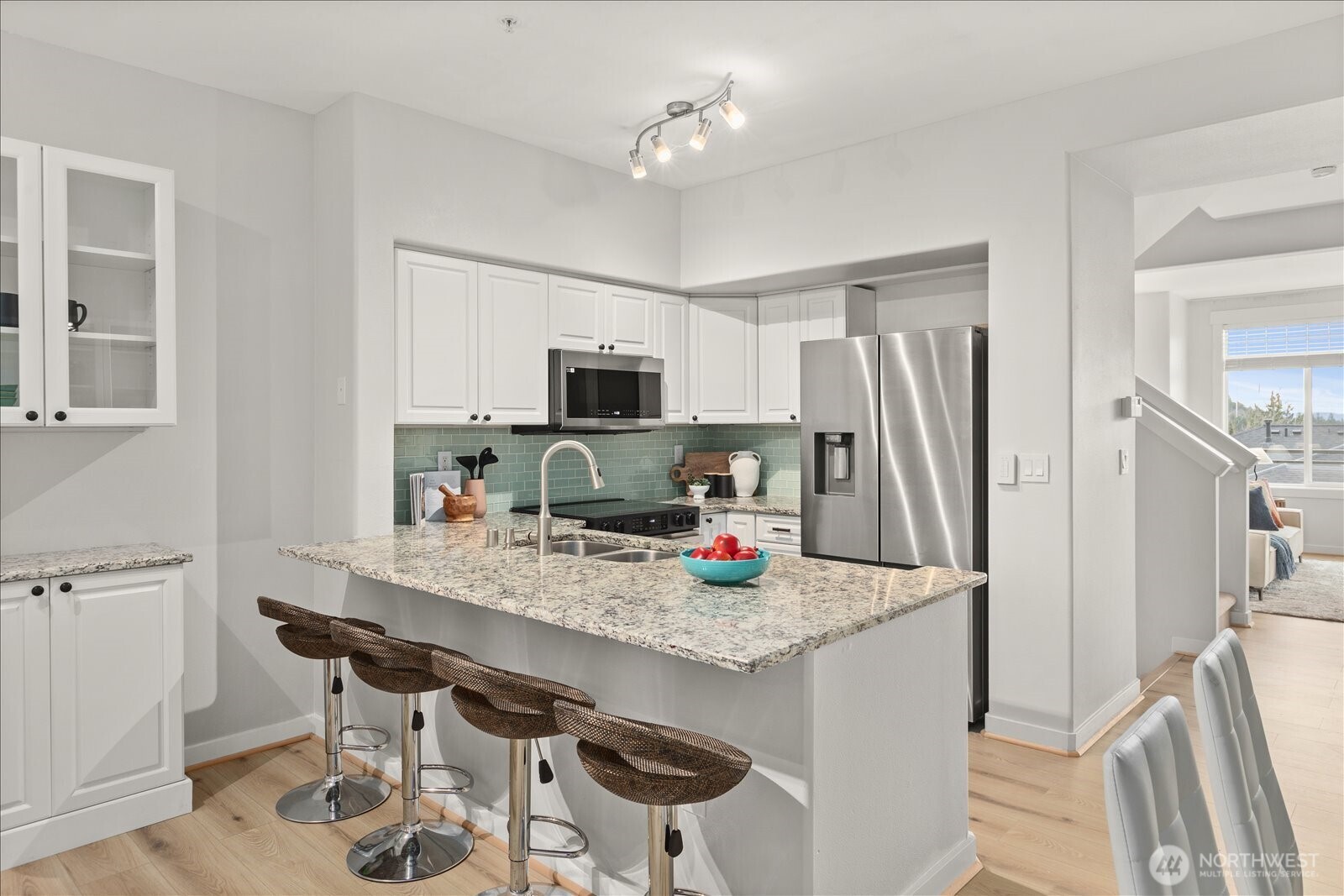 23300 Southeast Black Nugget Road, Unit D3 Issaquah, WA 98029 - Photo 10 of 35 a kitchen with stainless steel appliances a sink a stove a refrigerator cabinets and a dining table