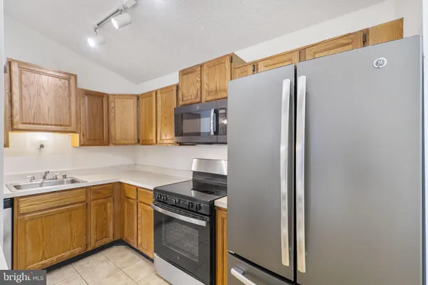 a kitchen with a sink stove top oven and cabinets