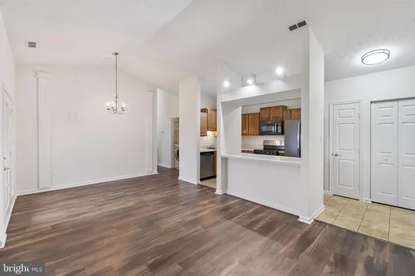 a view of a big room with wooden floor and a kitchen