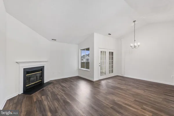 a view of an empty room with window and fire place