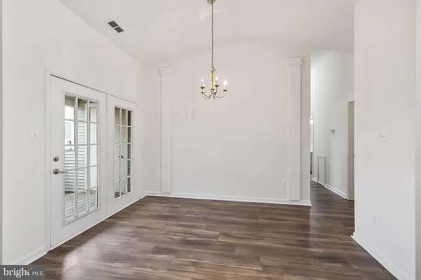 a view of a room with wooden floor and entryway