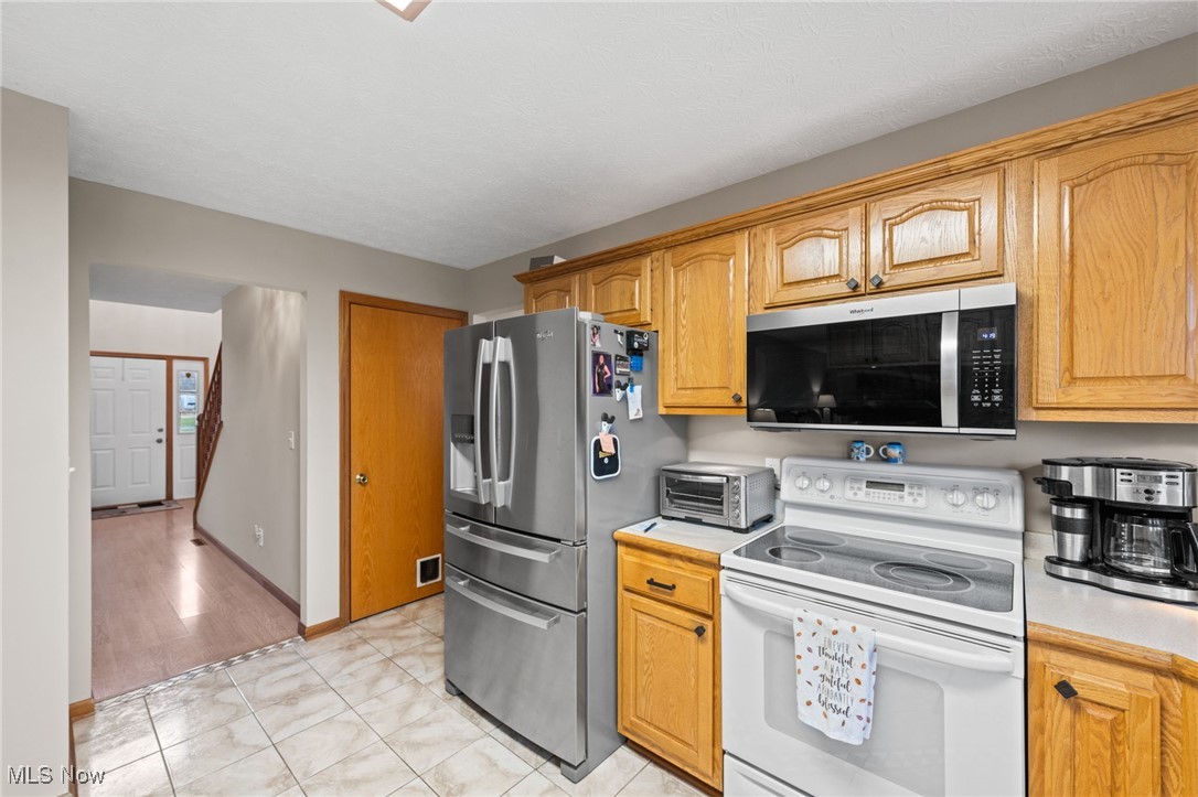 7939 Giddings Road Rootstown, OH 44272 - Photo 13 of 41 Kitchen with appliances with stainless steel finishes, light countertops, and light tile patterned floors
