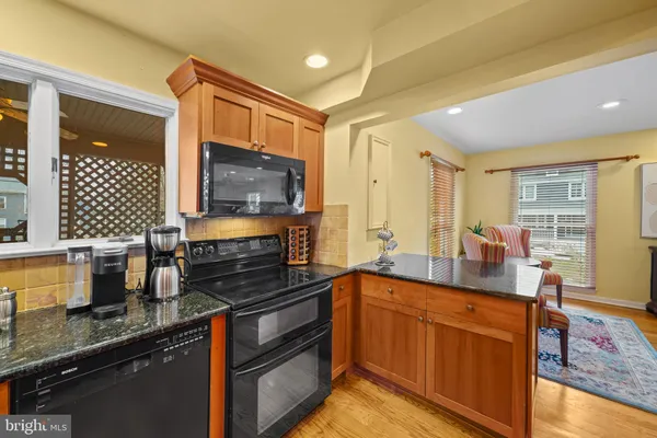 a kitchen with stainless steel appliances granite countertop a refrigerator a sink and wooden cabinets