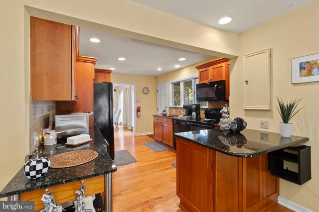 a kitchen with stainless steel appliances granite countertop sink refrigerator and window