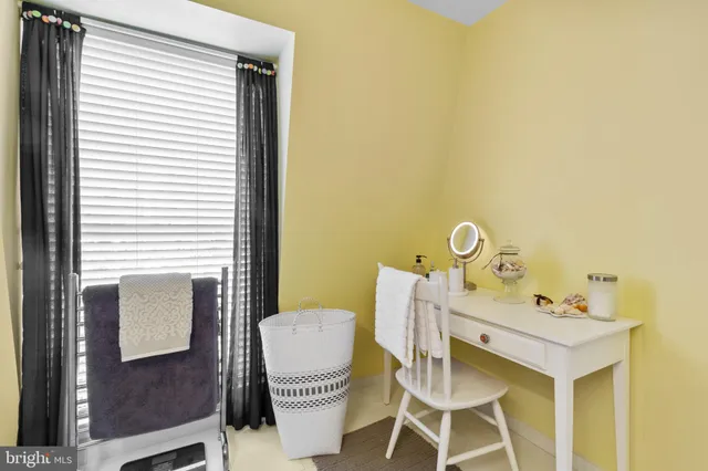 a view of a workspace with furniture and a window