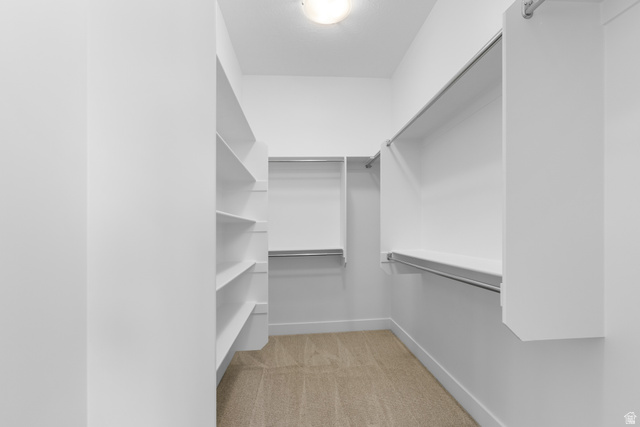 43 South Crimson Way, Unit 311 Mapleton, UT 84664 - Photo 16 of 28 Walk-in closet featuring built-in shelving, multiple hanging rods, white walls, and neutral carpet flooring