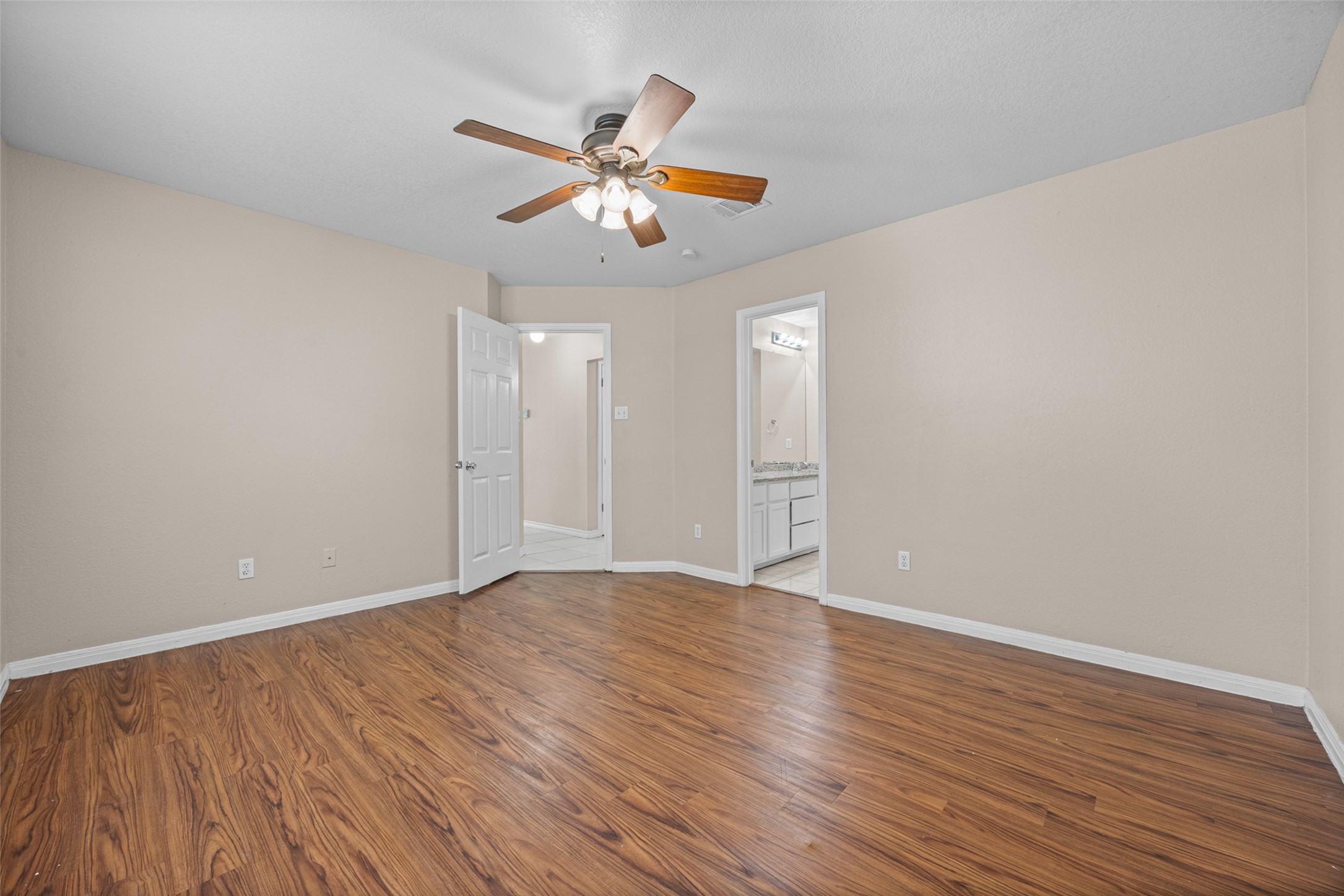 2432 Roundabout Lane Round Rock, TX 78664 - Photo 12 of 22 A comfortable bedroom boasts rich wood flooring and a refreshing ceiling fan.