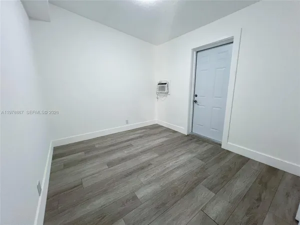 an empty room with wooden floor and closet