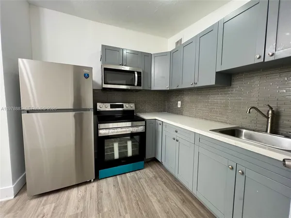 a kitchen with stainless steel appliances granite countertop a refrigerator sink and stove
