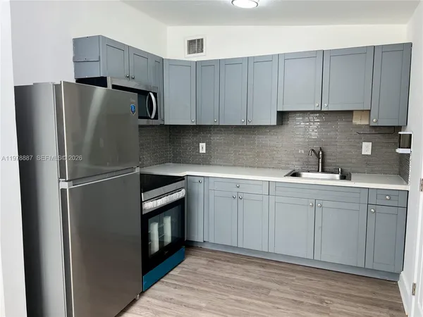 a kitchen with stainless steel appliances granite countertop a refrigerator sink and cabinets
