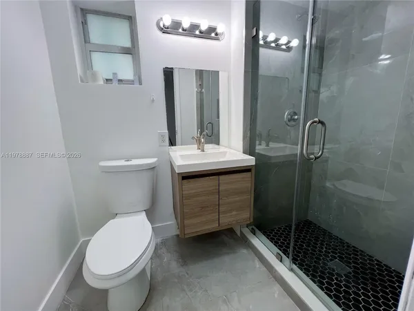 a bathroom with a sink a toilet and shower