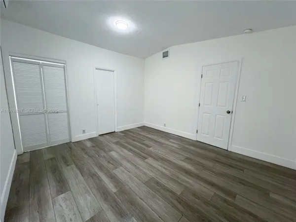 a view of a room with wooden floor