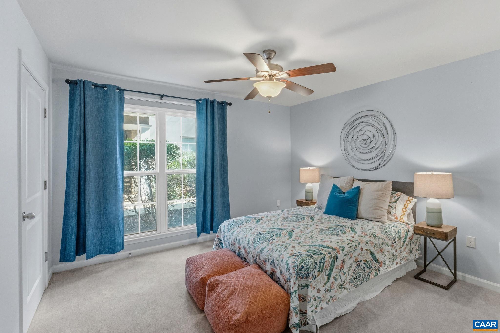 720 Walker Square, Unit 1B Charlottesville, VA 22903 - Photo 15 of 29 a bedroom with a large bed and a chandelier