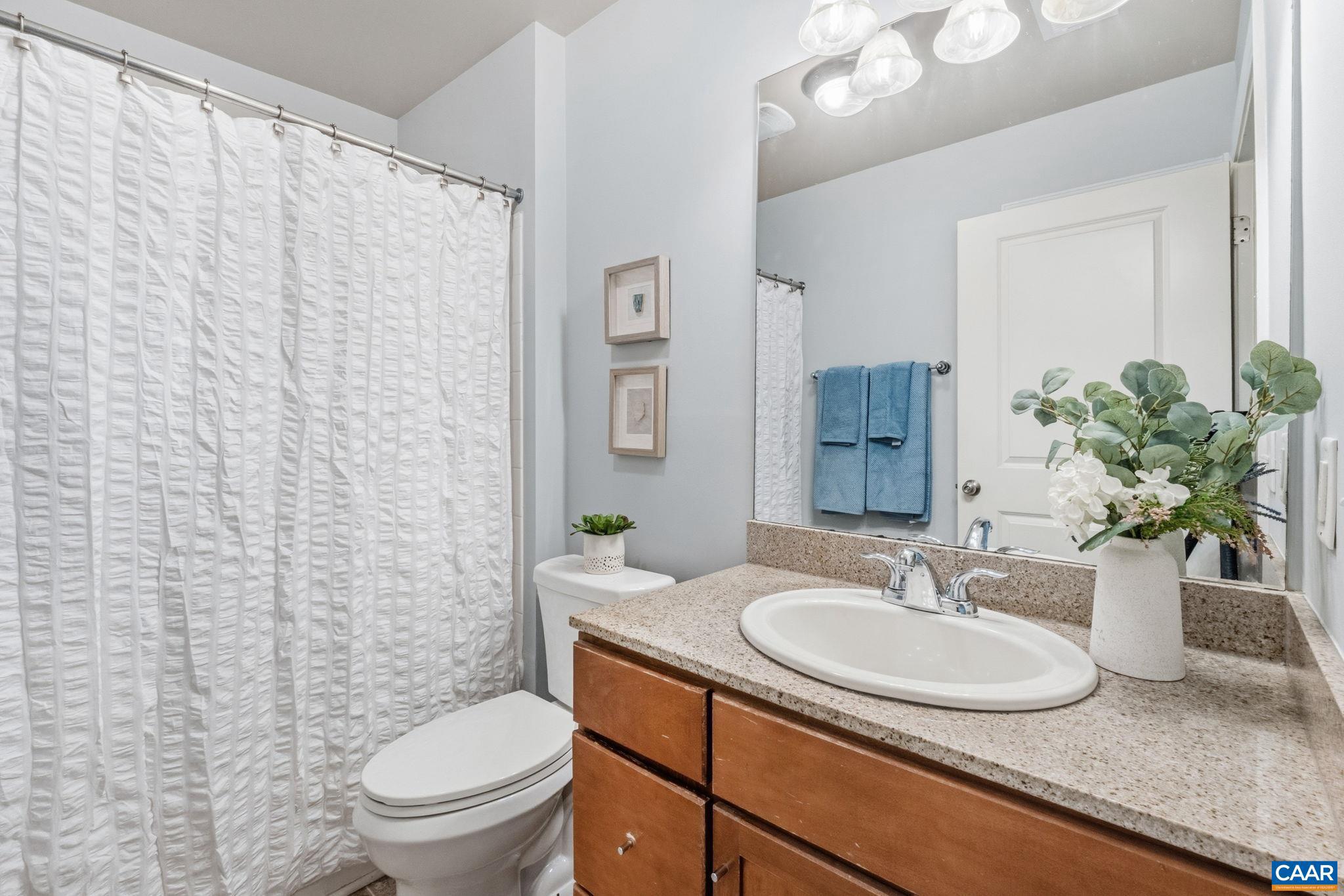 720 Walker Square, Unit 1B Charlottesville, VA 22903 - Photo 18 of 29 a bathroom with a granite countertop sink and a mirror with toilet
