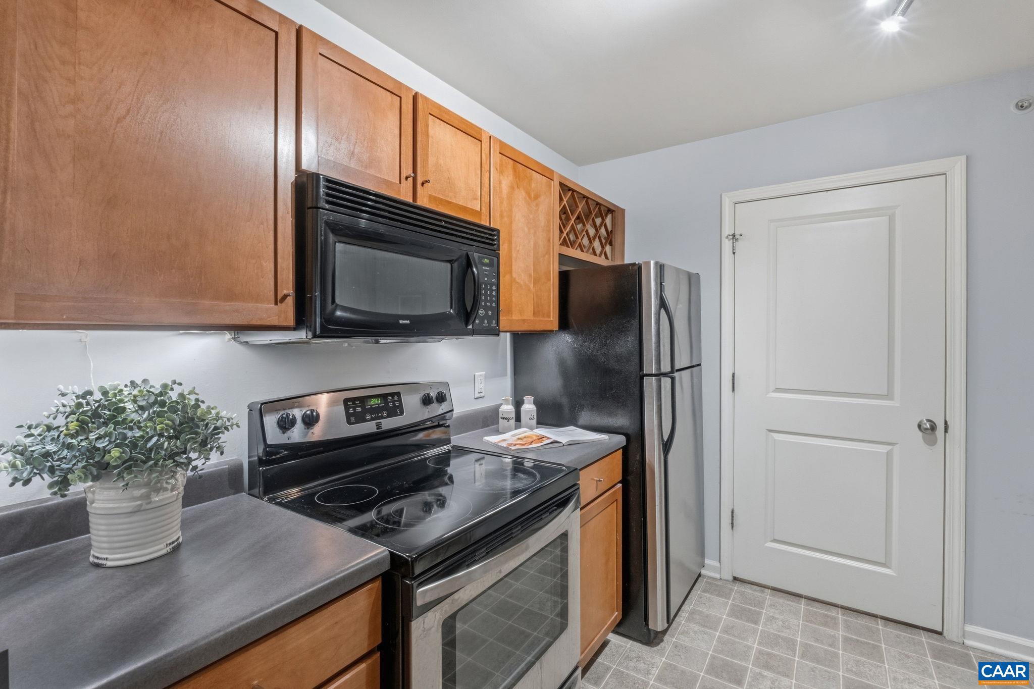 720 Walker Square, Unit 1B Charlottesville, VA 22903 - Photo 8 of 29 a kitchen with stainless steel appliances granite countertop a refrigerator and a stove top oven