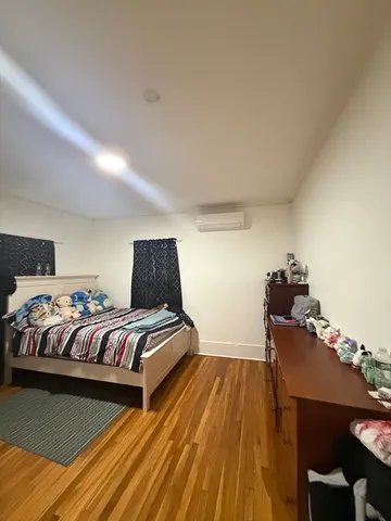 a bed sitting in a bedroom next to a window with a tv