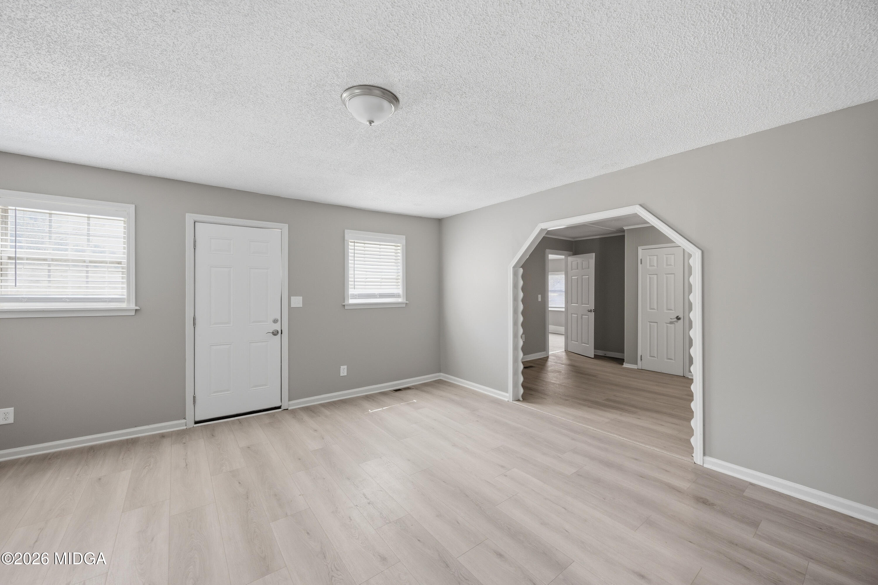 427 Gun Club Road Fort Valley, GA 31030 - Photo 9 of 26 a view of an empty room with wooden floor and a window