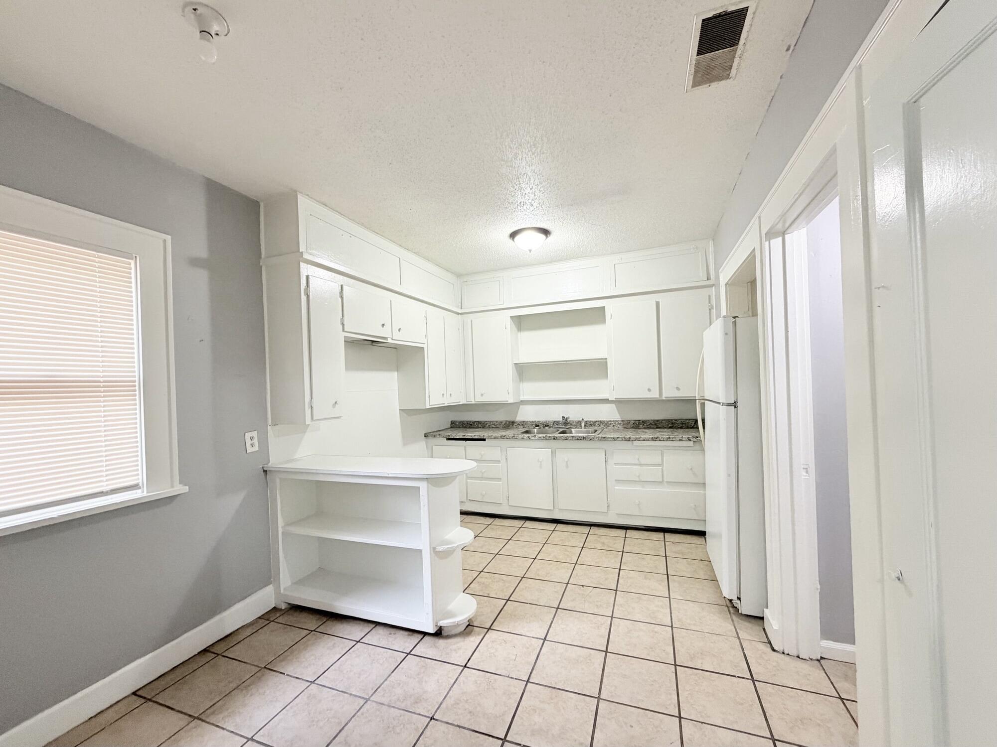 2119 15th Street Lubbock, TX 79401 - Photo 5 of 15 a kitchen with stainless steel appliances a sink and a refrigerator