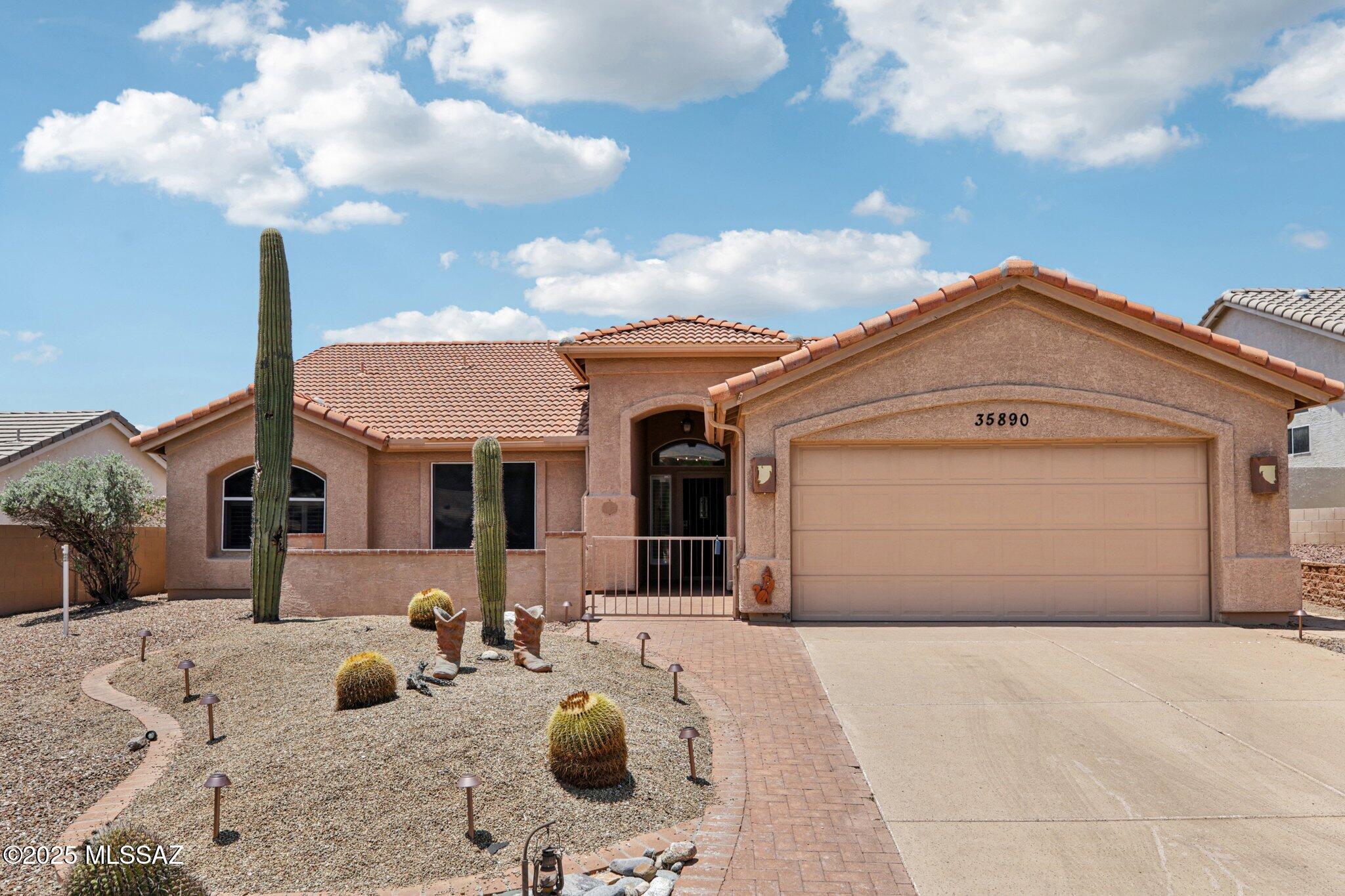 35890 Mesa Ridge Drive Tucson, AZ 85739 - Photo 30 of 31 a front view of a house with a yard and garage