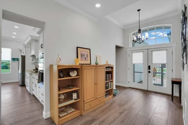 a view of a kitchen and an empty room with wooden floor