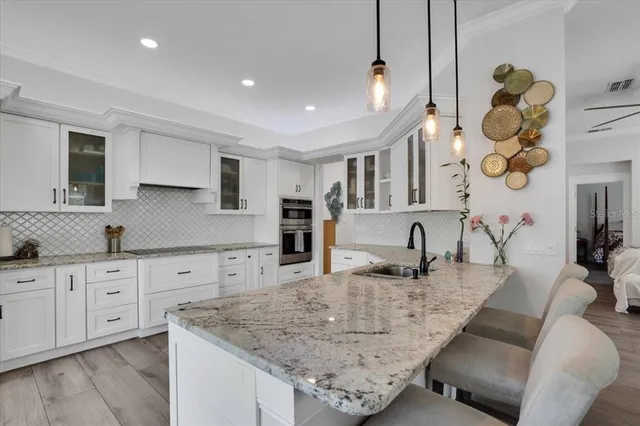 a kitchen with granite countertop a sink a stove and cabinets