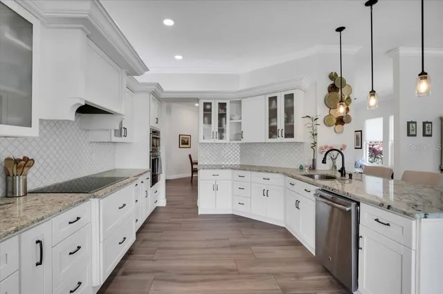 a kitchen with white cabinets and sink
