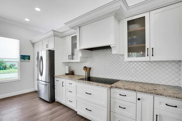 a kitchen with granite countertop a sink stainless steel appliances and cabinets